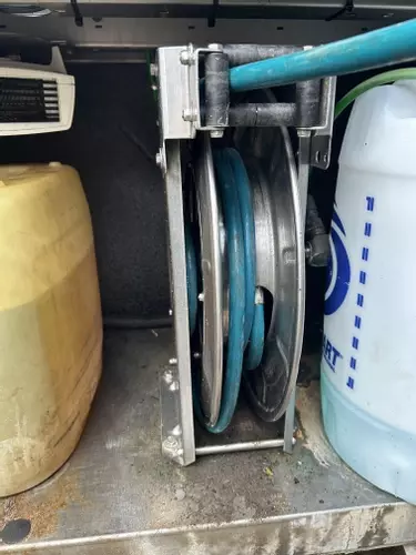 Internal hose reel installed inside Nilfisk SH Truck pressure washer cabinet protecting hose from frost damage.